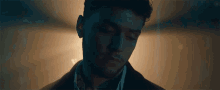 a close up of a man 's face with his eyes closed in a dark room .