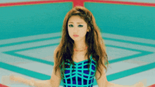 a woman in a blue and black plaid top is standing in front of a geometric background