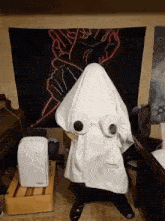 a person is wearing a ghost costume with toilet paper eyes .