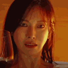 a close up of a woman 's face with a glass of water in front of her .