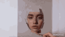 a person is painting a woman 's face on a piece of paper with a brush .
