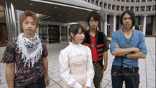 a girl in a white dress is standing between two men with their arms crossed