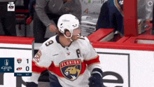 a hockey player for the florida panthers stands on the ice