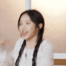 a blurry picture of a woman with pigtails and a white shirt .