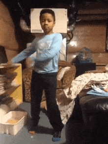 a boy in a blue shirt is dancing in a room with a box on the wall that says ' humidifier ' on it
