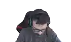a man with glasses and a beard is sitting in a chair