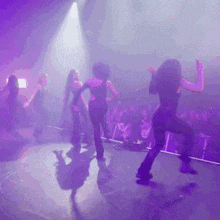a group of women are dancing in front of a crowd