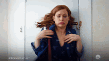a woman in a blue shirt is standing in front of a door with #zoeysplaylist written on the bottom