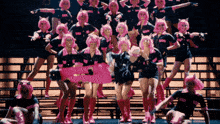 a group of women wearing pink wigs and black shirts with the letter a on them