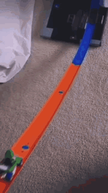 a hot wheels track with a green car on it