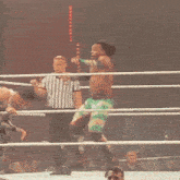 a wrestler in a white tank top with the word wrestling on the back is in a ring