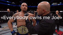a man with a ufc belt is being interviewed by a bald man