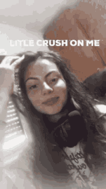 a woman wearing headphones is posing for a picture with the caption little crush on me