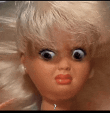 a close up of a doll with a question mark on the bottom