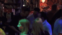 a group of people are dancing in a dark room with a man wearing a white shirt that says ' ambulance '