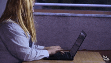 a woman is typing on a laptop in front of a sign that says that 's gamble