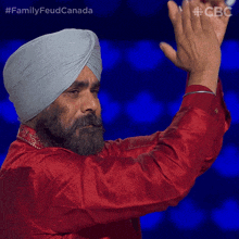 a man wearing a turban and a red shirt applauds with the hashtag familyfeud canada