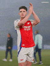 a soccer player wearing a red emirates fly jetters jersey