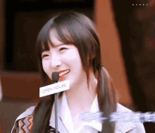 a girl with pigtails is smiling while wearing an open house sign