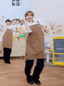 a man in an apron is dancing in front of a sign that says open