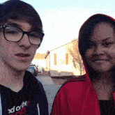 a boy and a girl are posing for a picture and the boy is wearing glasses