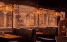 a blurry picture of a diner with tables and chairs and lamps .