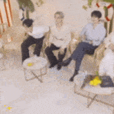 a group of people are sitting around a table in a living room