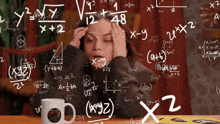 a woman sits at a table with a mug that says emm