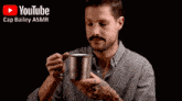 a man with a mustache is holding a cup and says " truly remarkable "