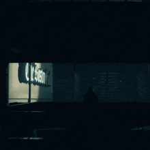 a shadow of a person stands in front of a sign that says le boston