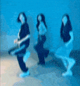 a blurry picture of three women dancing in a blue room