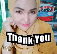 a woman wearing a yellow shirt and a hijab says " thank you "