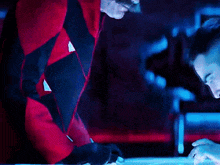a man in a red jacket is looking down at something