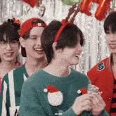 a group of young men wearing christmas hats and sweaters with a gif written on the bottom right