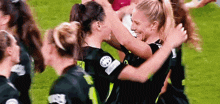 a group of women are hugging each other on a field .