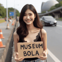 a woman is holding a sign that says museum bola