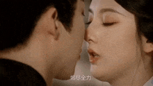 a man and a woman are kissing with chinese writing on the bottom right