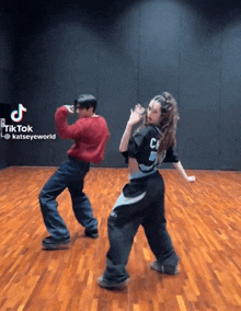 a man and a woman are dancing in front of a tiktok logo