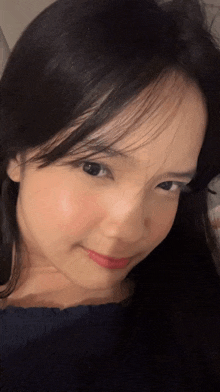 a close up of a woman 's face with a blue shirt on