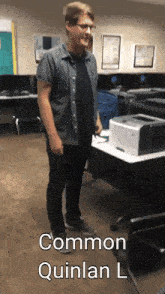 a man standing in front of a printer with the name quinlan l