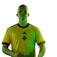 a man wearing a yellow adidas shirt with a celtic cross on it