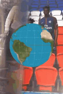 a globe with a car in the background and people walking behind it
