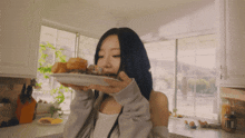 a woman with blue hair is eating from a plate in a kitchen