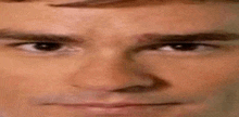 a close up of a man 's face with a slight smile on his face .