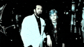a man with a beard wearing a white suit and black tie