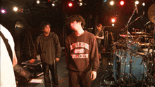 a man in a brown sweatshirt that says twin crew