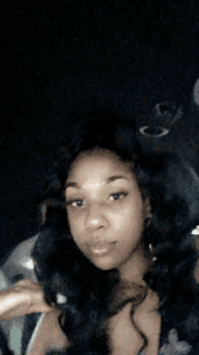 a woman is sitting in the back seat of a car holding a cigarette in her hand .