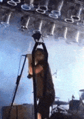 a man singing into a microphone while standing on a stage