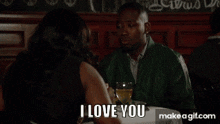 a man and a woman are sitting at a table and the woman says i love you