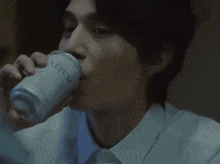 a man is drinking from a can that says lychee